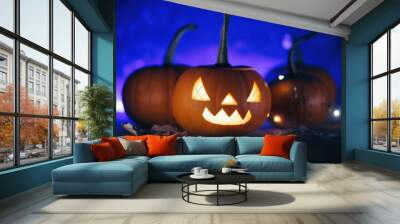 Creepy evil carved pumpkin on a blue background . Halloween Wallpaper Wall mural