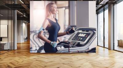 Happy women jogging on a treadmill for health. Wall mural