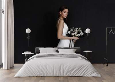 Beautiful woman in a white wedding dress on a black background. A modern trendy bride in an elegant dress. Wall mural