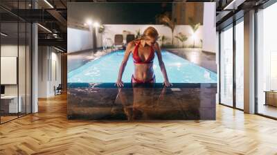 Girl in a swimsuit swimming in the pool at the Villa. Swimming under water in the night. Wall mural