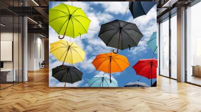 Colorful umbrellas hanging above a street Wall mural