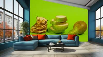 Dried pear chips, closeup shot on a green background. Background for a healthy diet. Wall mural