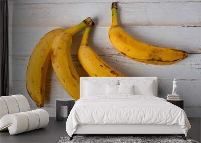 Ripe bananas on a white wooden tabletop background. Background for healthy eating and vegetarianism. Wall mural