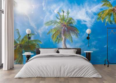 Green palm trees on background of blue sky and white clouds Wall mural