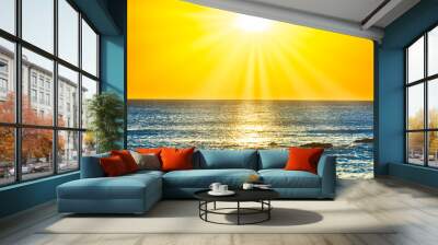 Sunset sea and beach with rocks and sunset sun on dramatic sky Wall mural