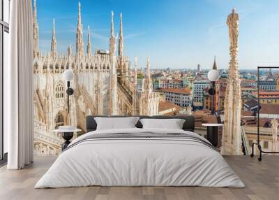 White statue on top of Duomo cathedral and view to city of Milan Wall mural