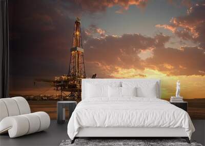 Oil drilling rig at sunset in a vast desert landscape Wall mural