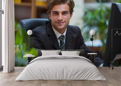 Young businessman working at a desk in an office surrounded by plants Wall mural