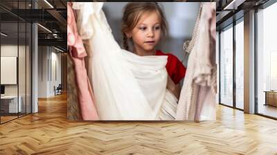 little girl adorably little girl choosing clothes trying on a new dress. high quality photo Wall mural