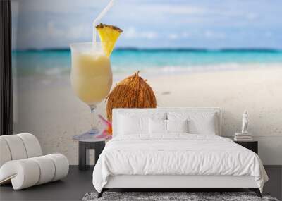 Pina Colada cocktail on the beach with coconut and exotic flower Wall mural