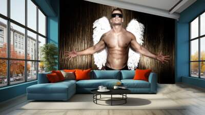 Conceptual photo of handsome, muscular male angel. Wall mural