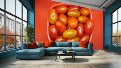 Cherry tomatoes in a glass bowl on a red background Wall mural