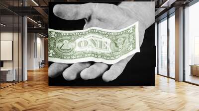 Hand holding one dollar bill. Paying the fee background. Flat hand with banknote on it. Banking and finance backdrop. Giving money hand isolated on black. Wall mural