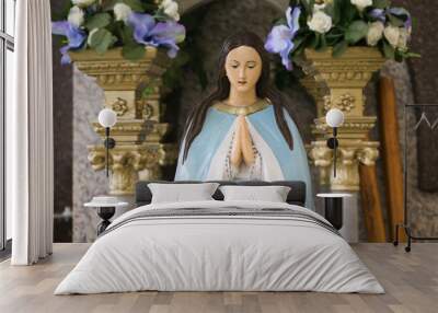 Mother Mary pray. Blessed virgin statue. Rosary in hands. Wall mural