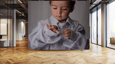 portrait of little boy wearing a big shirt from his father Wall mural