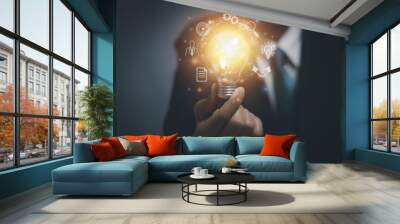 Close-up of businessman holding a bright light bulb, business idea concept, creativity ,Inspire to develop the organization , science and communication technology Wall mural