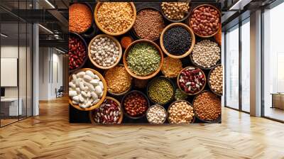 Legumes, a set consisting of different types of beans, lentils and peas on a black background, top view. The concept of healthy and nutritious food Wall mural