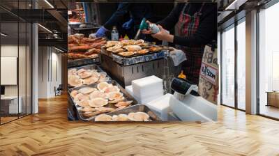 osaka, japan january 3, 2020: the shop is cooking the scallops in kuromon fresh market in japan. Wall mural