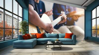 Christian family worship God in home with  playing guitar, and holding holy bible .Group christianity people reading bible together.Concept of wisdom, religion, reading, imagination. Wall mural