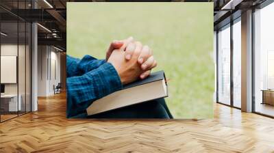 Christians and Bible study concept.Young man sitting and prayer on bible.copy space Wall mural