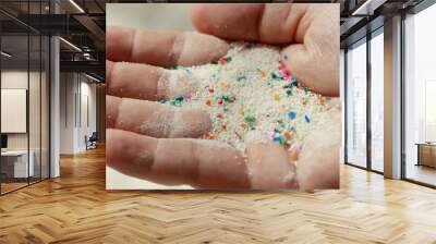 Close-up hand shows microplastic waste contaminated with the seaside sand. Microplastics are contaminated in the sea. Concept of water pollution and global warming.Climate change idea. Wall mural