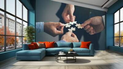 Concept of teamwork and partnership. Hands join puzzle pieces in the office. business people putting the jigsaws team together.Charity, volunteer. Unity, team business. Wall mural