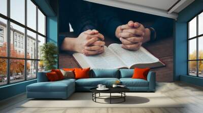 Couples holding hands together and praying on the holy bible. believe in goodness. online group worship, world day of prayer, international day of prayer, worship and religion. thankful, trust concept Wall mural