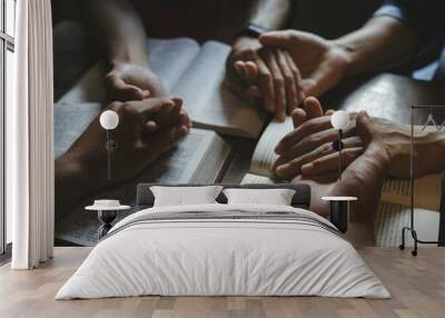 Group of people holding hands praying worship believe with bible on a wooden table for devotional for prayer meeting. Christians and Bible study concept.believe in goodness. Wall mural