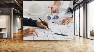 Two business man construction site engineers. working drawing on blueprint and discussing the floor plans over blueprint architectural plans at table in a modern office. construction concept Wall mural