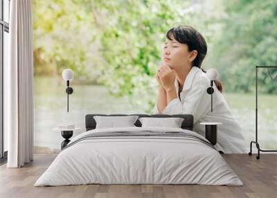 Woman praying in the morning on nature background.Hands folded in prayer on a Holy Bible in church concept for faith, spirituality and religion Wall mural