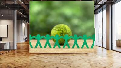 World Earth Day Concept. Environmental Care. Paper People holding hands standing in front of a green earth. Environmental protection cooperation.Protecting Planet Together, ESG, Sustainable Resources. Wall mural