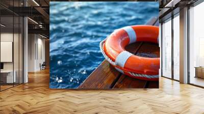 Bright Orange Lifebuoy on Wooden Deck by the Water Symbolizing Safety and Risk Mitigation in Maritime Environments Wall mural