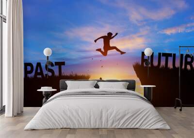 Silhouette man jumping from PAST to FUTURE wording on cliffs with cloud sky and sunrise. Go ahead and Keep go on to success Concept. Wall mural