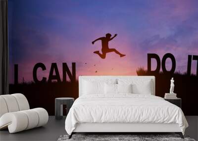 Silhouette man jumping over I can do it wording on cliffs with cloud sky and sunrise. Never give up, Good mindset, and Successful achievement Concept. Wall mural