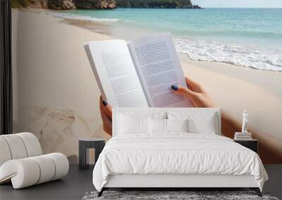 People hands holding a white book mock-up with copy space in front of a beautiful beach , woman read a book on the beach in summer concept image Wall mural