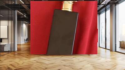 perfume or eau de toilette in black square glass bottle arranging on red fabric background Wall mural