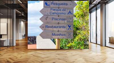 Wooden direction signs with various information on tourist points of interest, cycle path, fishing spot, campsite, cycle path, restaurant, windmills. São Jorge Island-Azores-Portugal Wall mural