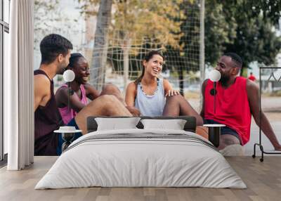 Friends sitting on the court talking after a basket game Wall mural