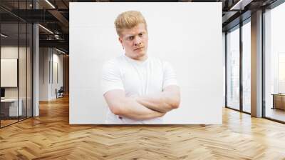 Monochrome: Portrait of an albino Latino man in white clothing against a white background. Wall mural