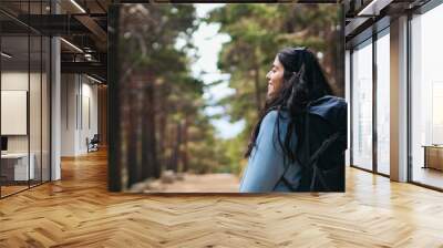 side view of a female hiker walking in the forest Wall mural