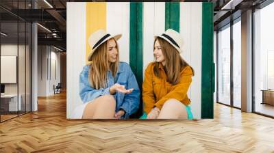 Two friends chatting calmly about their things, lies resting in some beach huts on a very colorful afternoon Wall mural