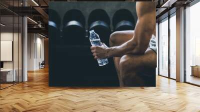 Fitness man drinking water in gym Wall mural