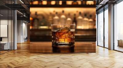 A classic presentation of Japanese whisky in a fine glass, on a dark wooden bar, with a blurred background of bar shelves filled with bottles Wall mural