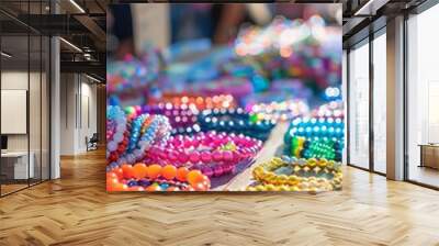 A variety of handmade beaded bracelets are displayed for sale at a street market. The bracelets are made from colorful glass beads, and they are all unique and one-of-a-kind. Wall mural