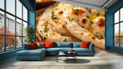 Butter naan, soft and fluffy bread with butter, served on a wooden board with a traditional Indian tandoor oven backdrop Wall mural