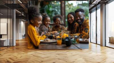 A joyful family of four, dressed in vibrant traditional attire, gathers around a table sharing a meal.  Wall mural