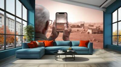 Back view Elderly man take photo with mobile phone with copy space. Wall mural