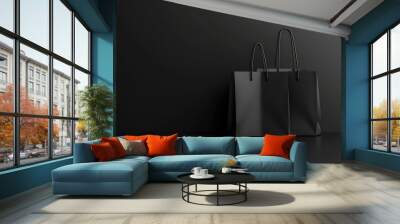 A minimalistic scene featuring two black shopping bags against a dark background, emphasizing simplicity and elegance. Wall mural