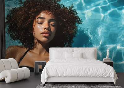 Under the summer sun, a woman with curly hair poses by the pool in a fashionable black swimsuit. The scene is set with clear blue water and a warm, inviting atmosphere. Wall mural