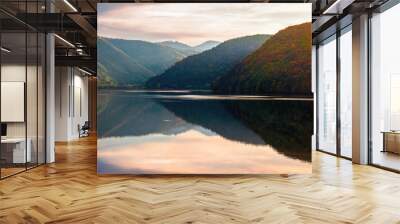 gilau lake of cluj country in evening light. beautiful landscape of romania in autumn. reflection on the calm water surface. trees in colorful foliage. sunny weather Wall mural